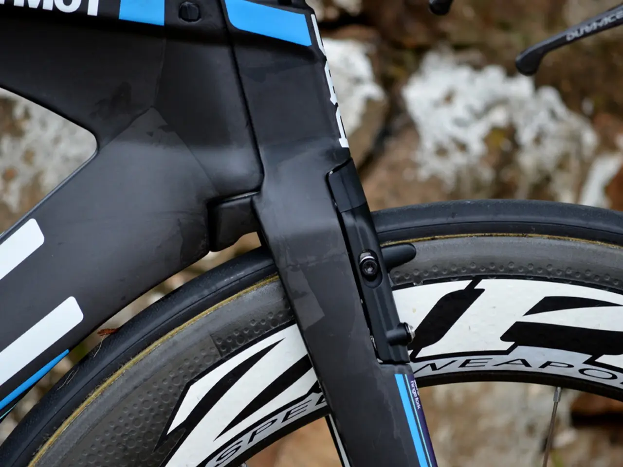 This picture shows a bicycle. It is black white and blue in color and we see text on it.