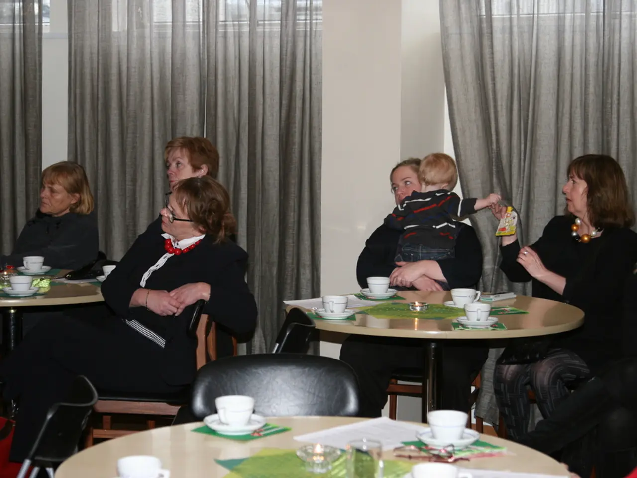 This image is taken in a restaurant there are many people sitting on the chairs. On the right there...