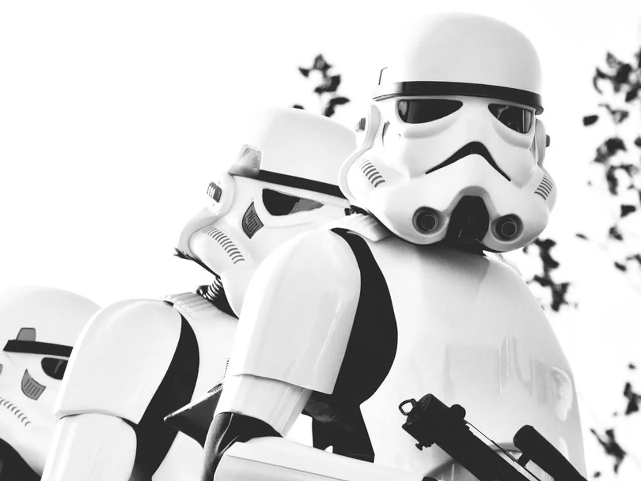 This is a black and white image and here we can see robots, plants and we can see a gun.