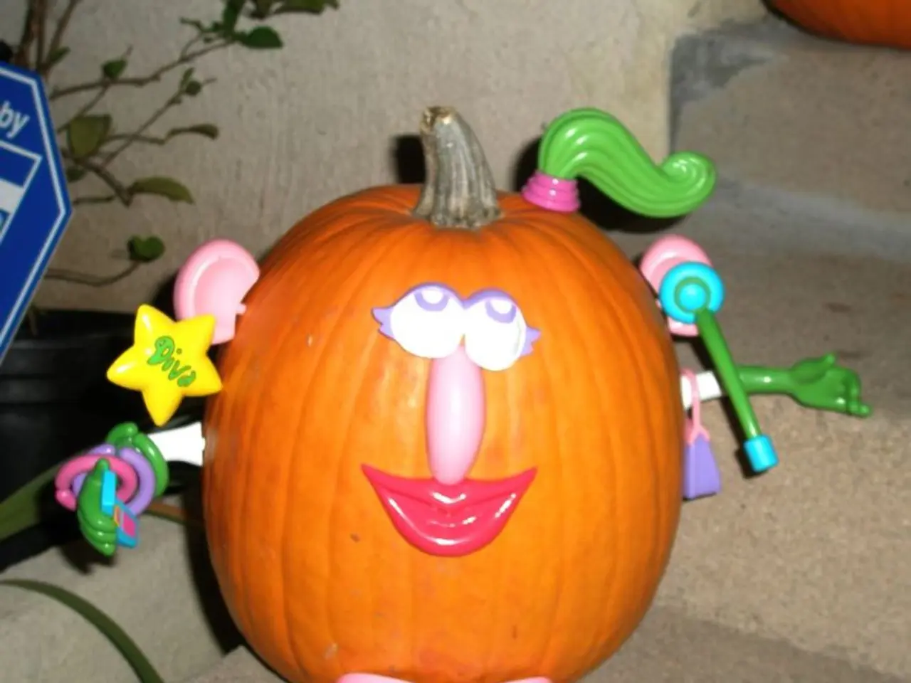 In this picture we can see a pumpkin on the stairs with some toys on it. There is a plant and a...