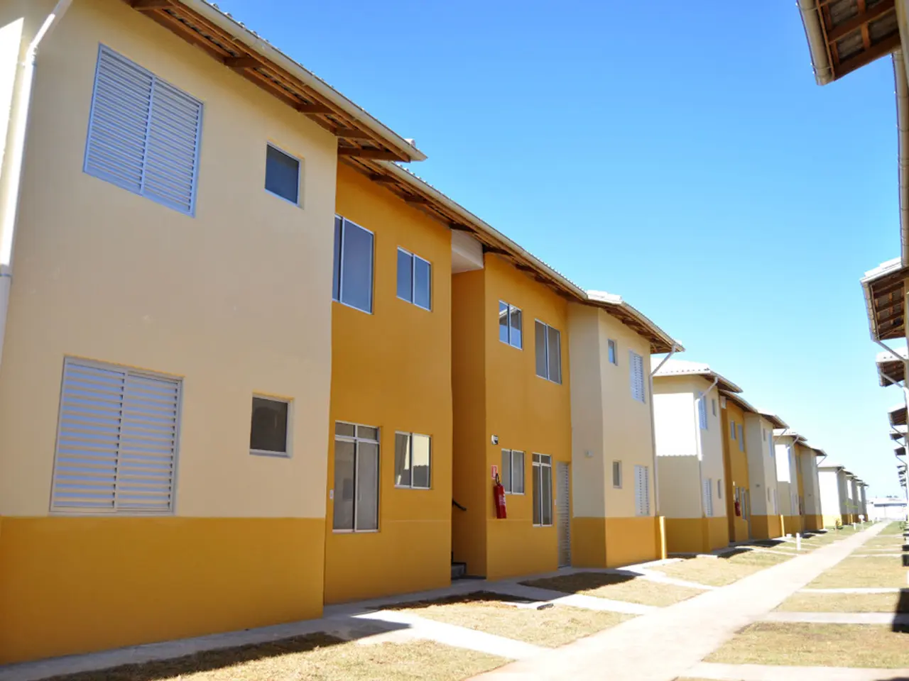 In this picture we can see houses in line with yellow colored wall. These are the windows. There is...