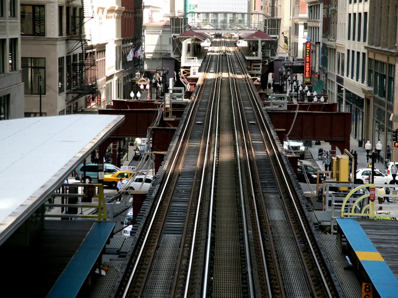 In this picture we can see a few railway tracks. There are street lights, persons, vehicles and...