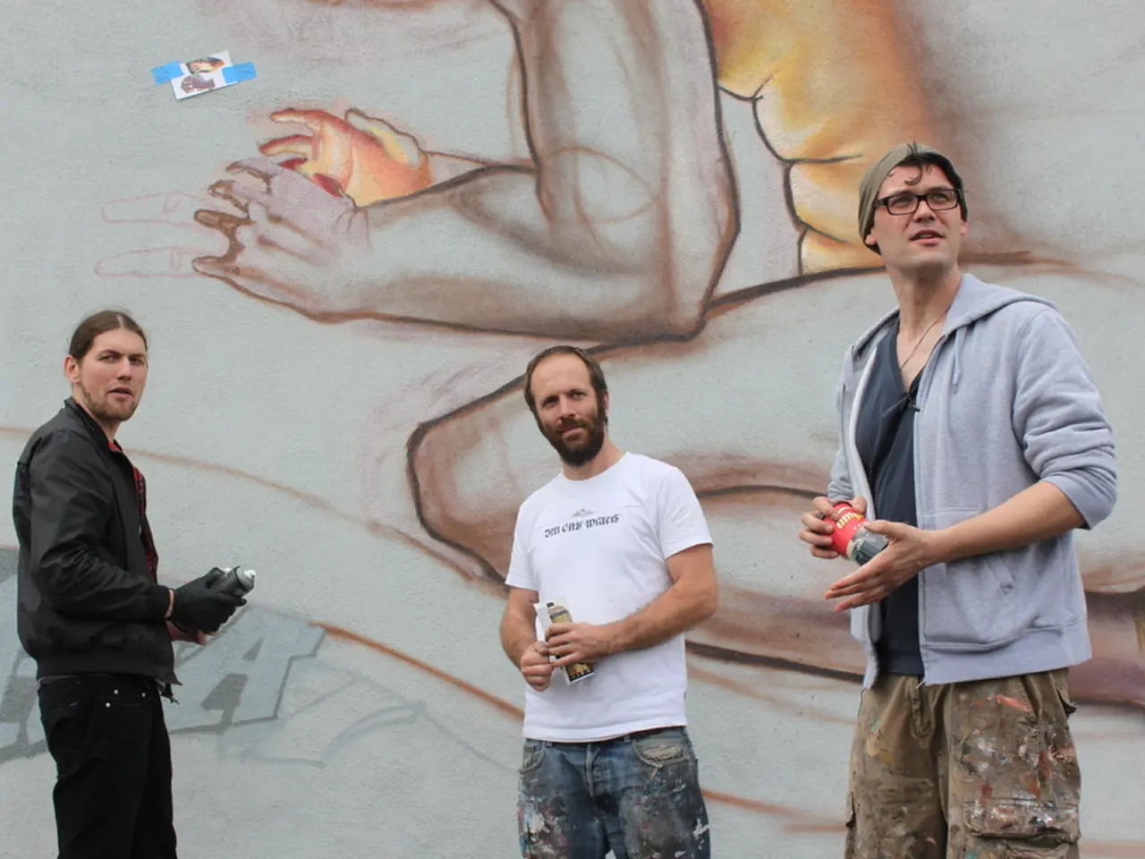 In the image we can see there are people standing and they are holding paint spray bottles in their...