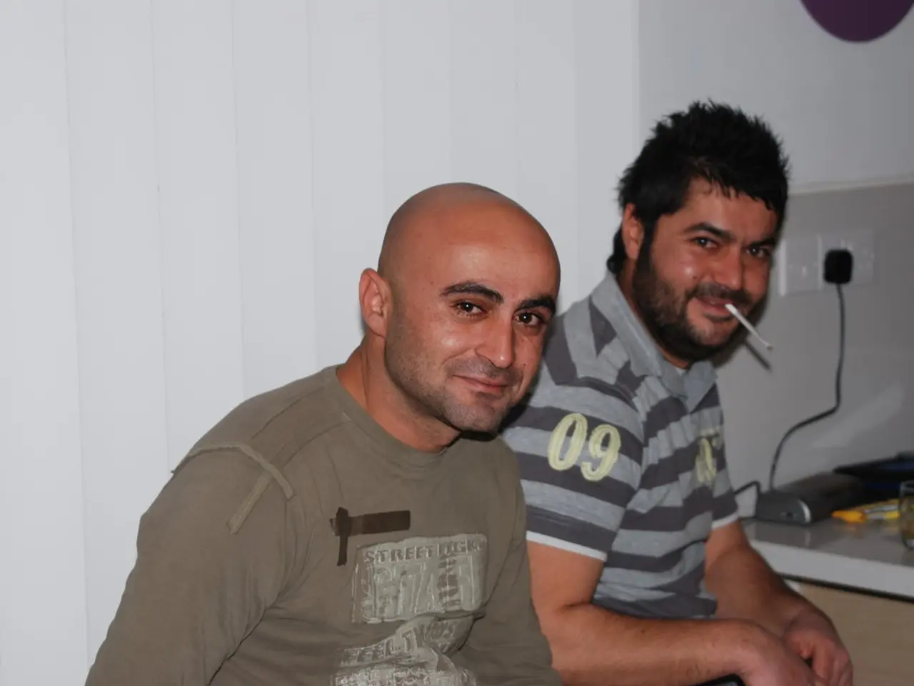 In this image we can see two plug sockets ,one is plugged in extension box and two persons are...