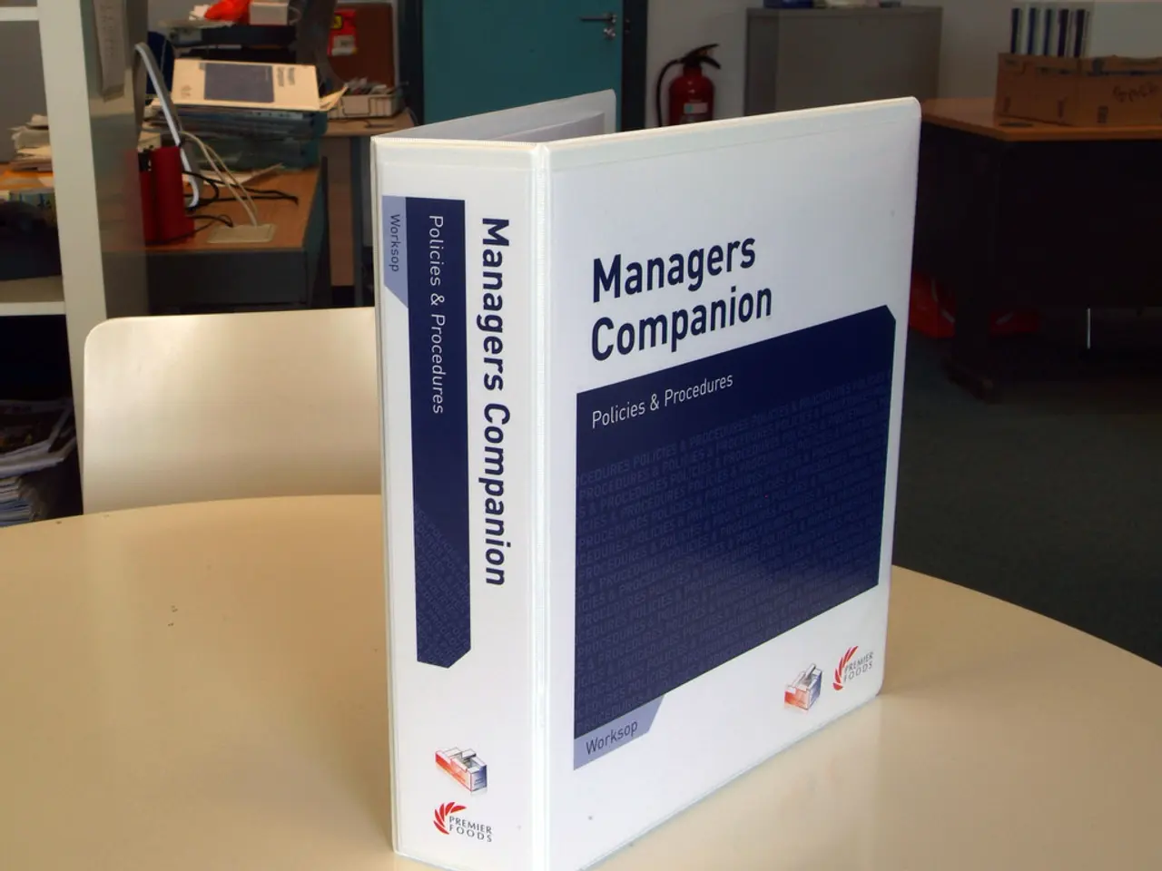 In the image there is a book kept on a table and behind the table there is a chair, behind the...