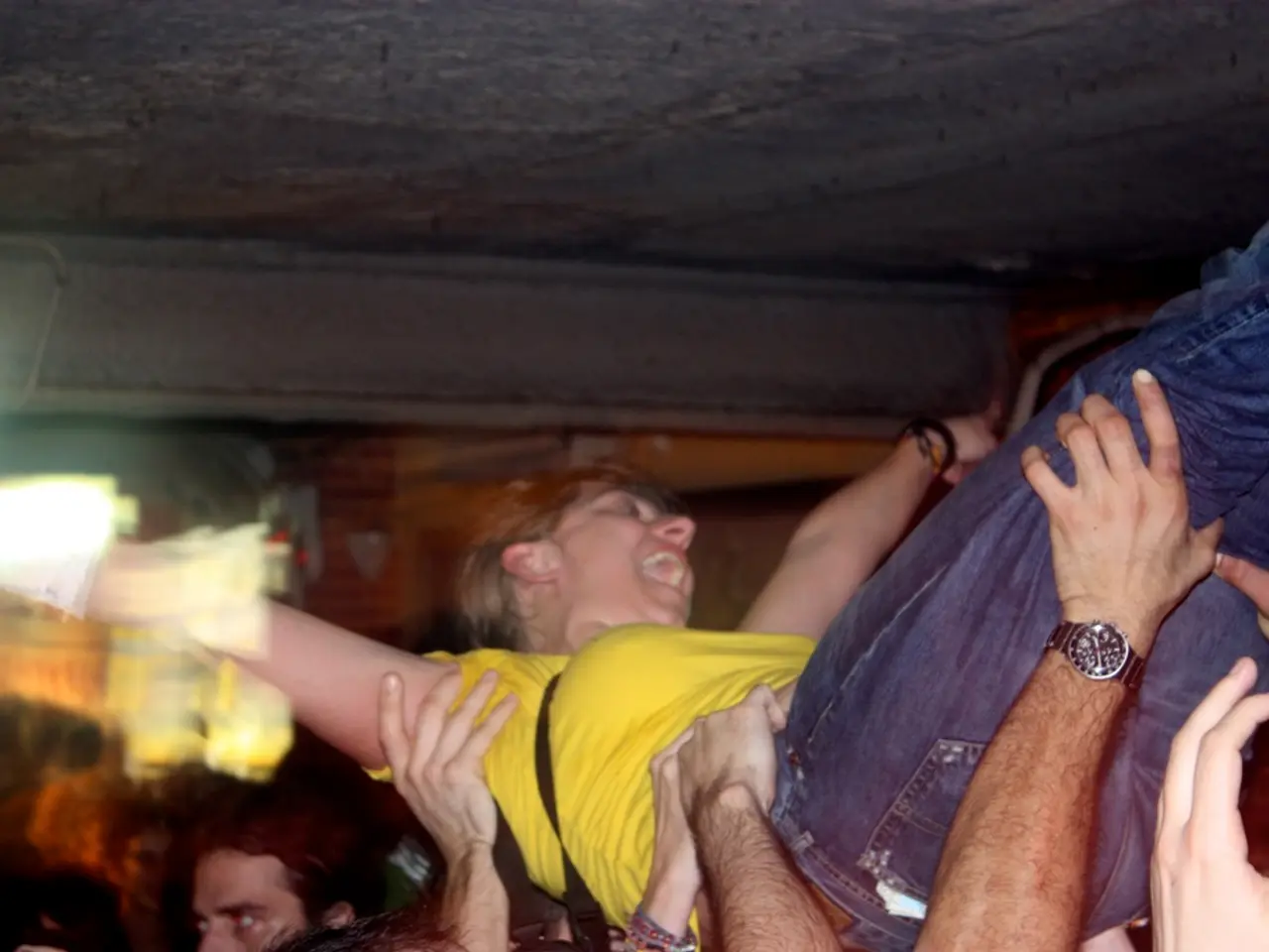 This is the women wearing yellow T-shirt and trouser. There are few people holding this woman. This...