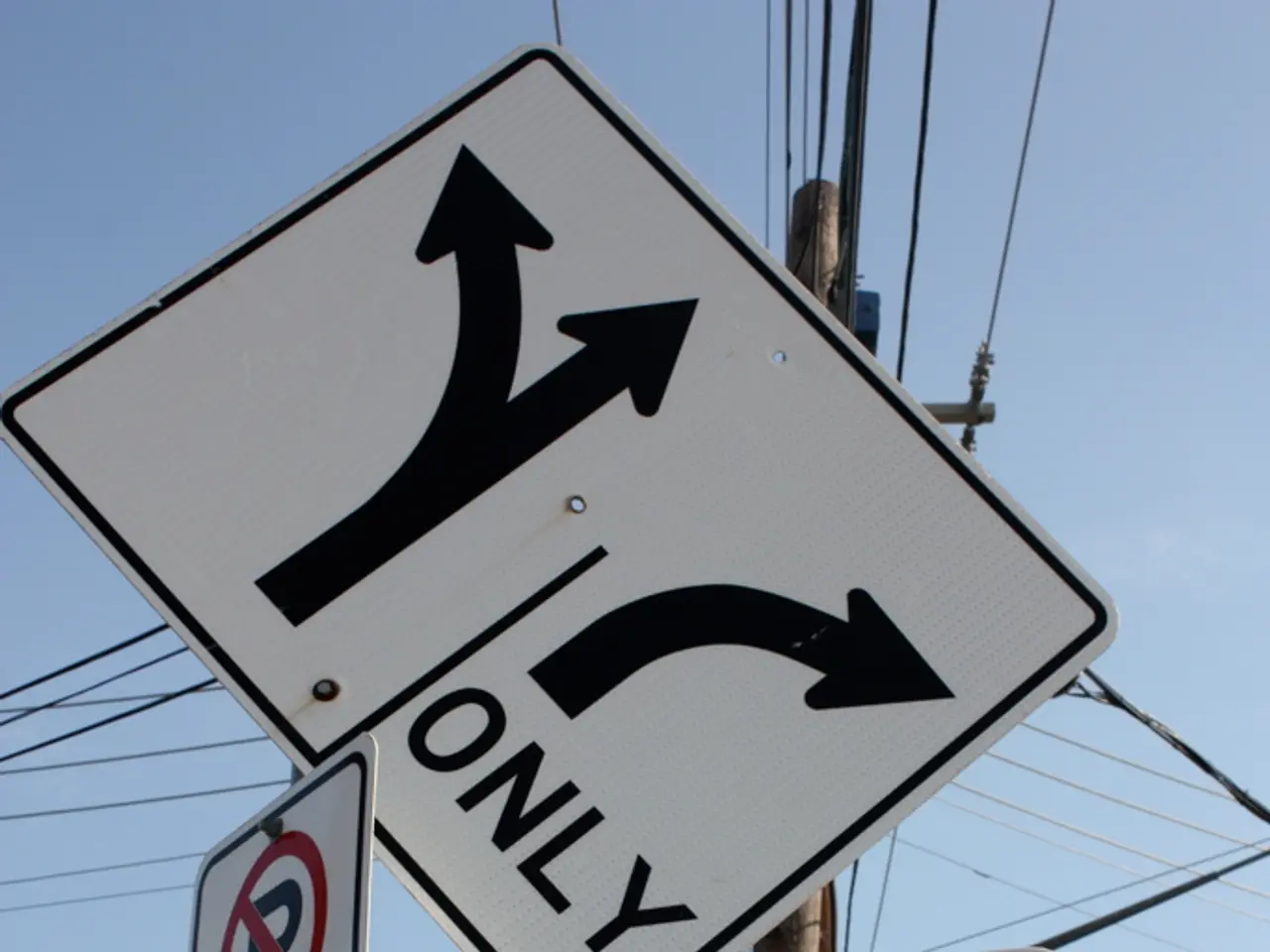 In this image, I can see a direction board, signboard and a caution board are attached to the...