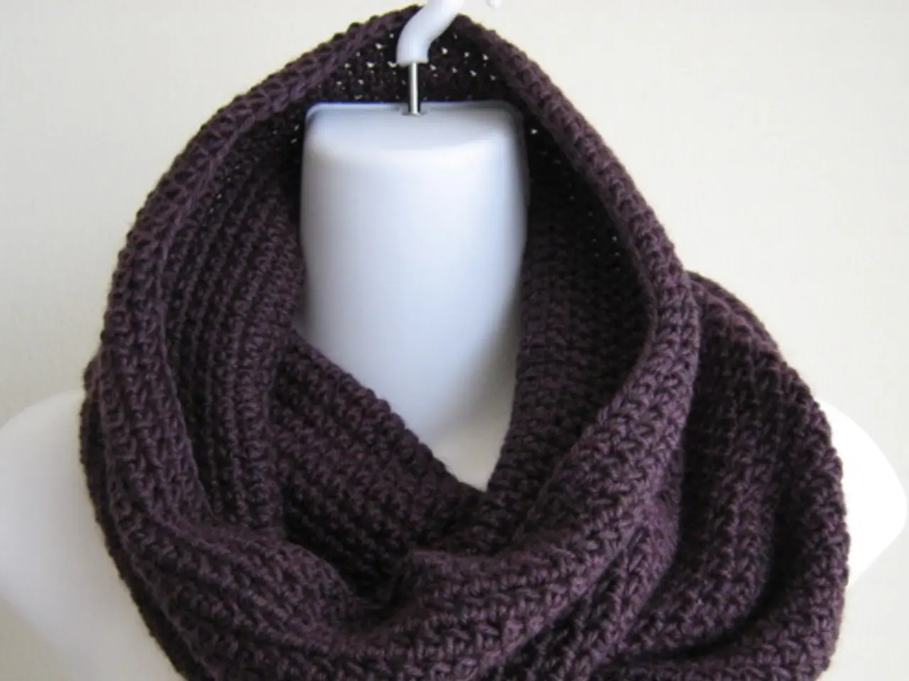 In this image we can see a stole hanged to the mannequin.