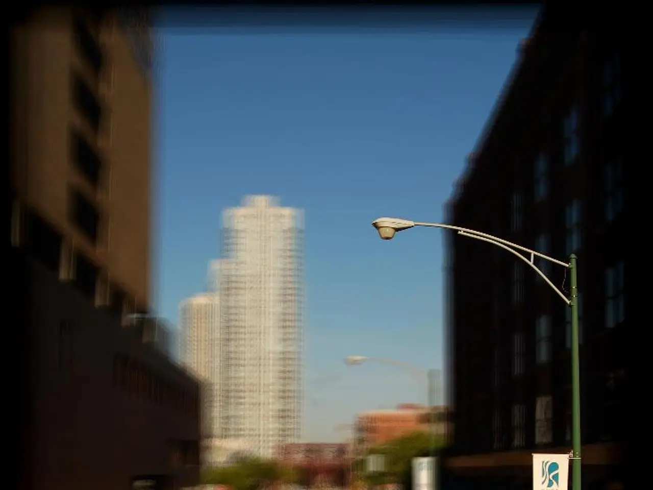 I can see cars on the road. This looks like a bicycle path. This is the street light. I can see a...