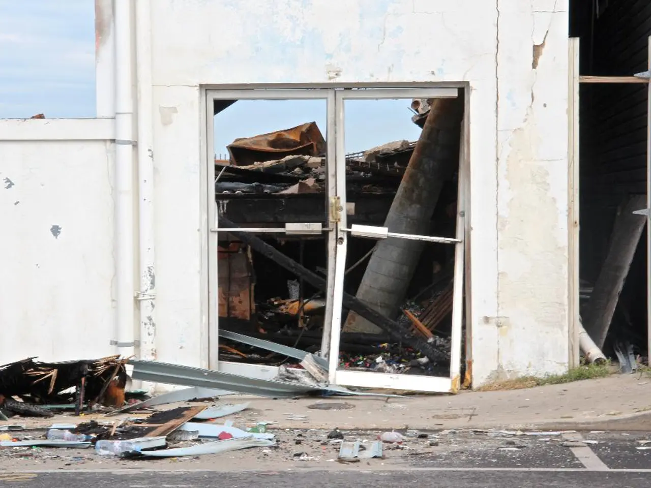 In this picture we can see a collapsed building and to the wall there are pipes. Behind the wall...