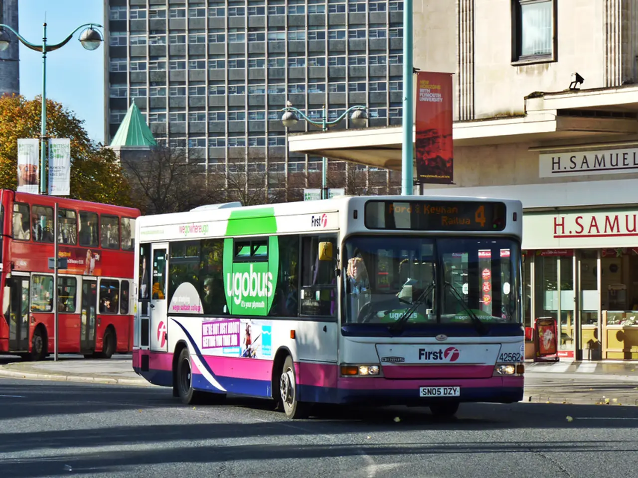 In the image we can see there are two buses standing on the road. On the other side of the buses...