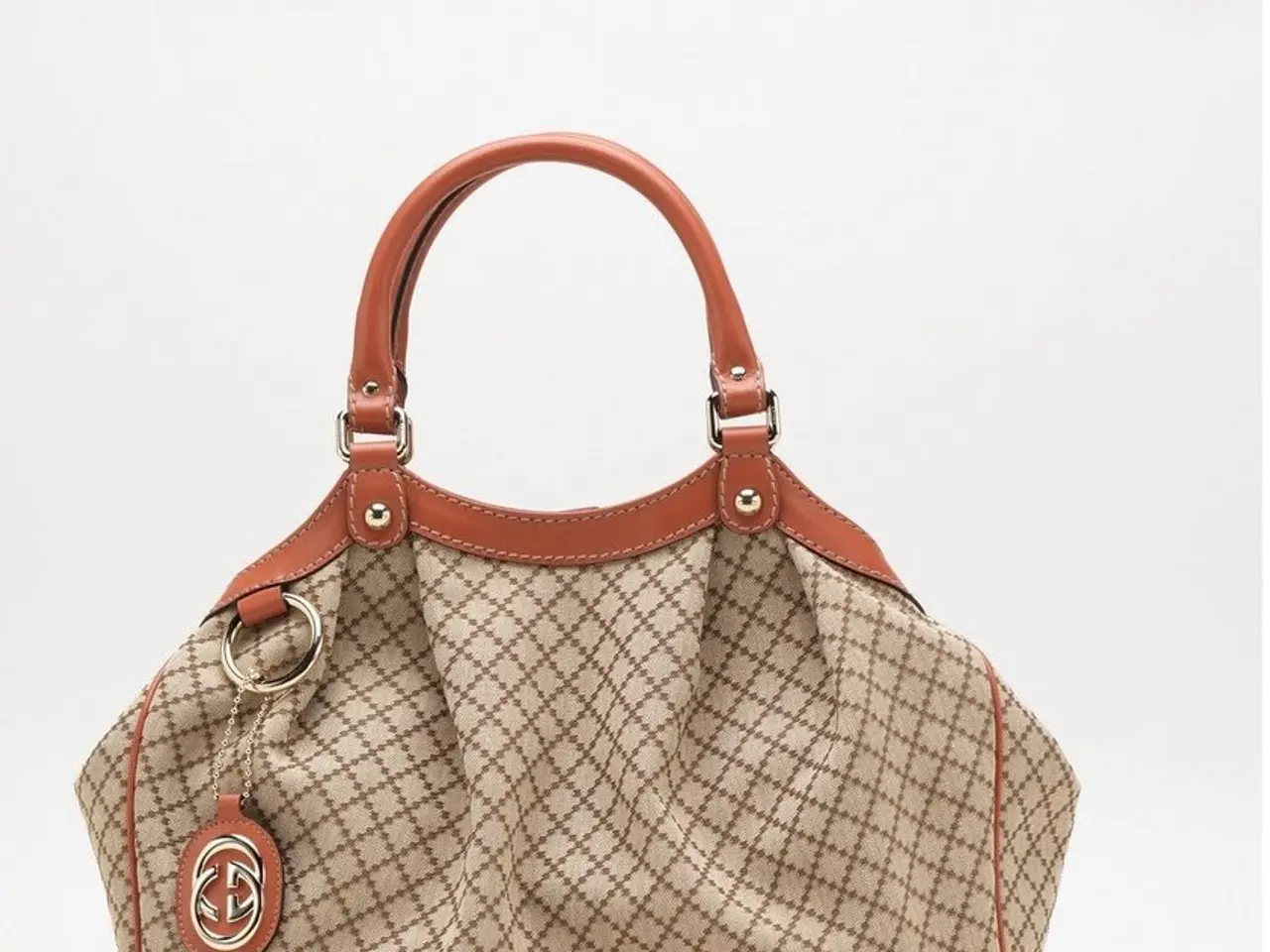 in this image the bag is placing on the floor and the bag color is chocolate and white color in...