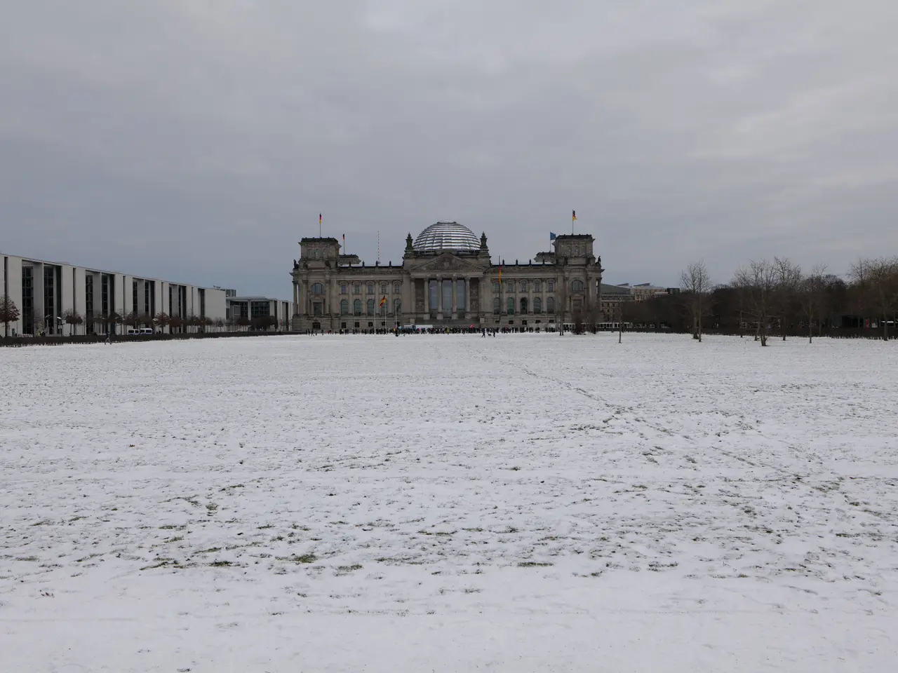 The image shows the Reichstag building in Berlin, Germany, covered in a blanket of snow. The...