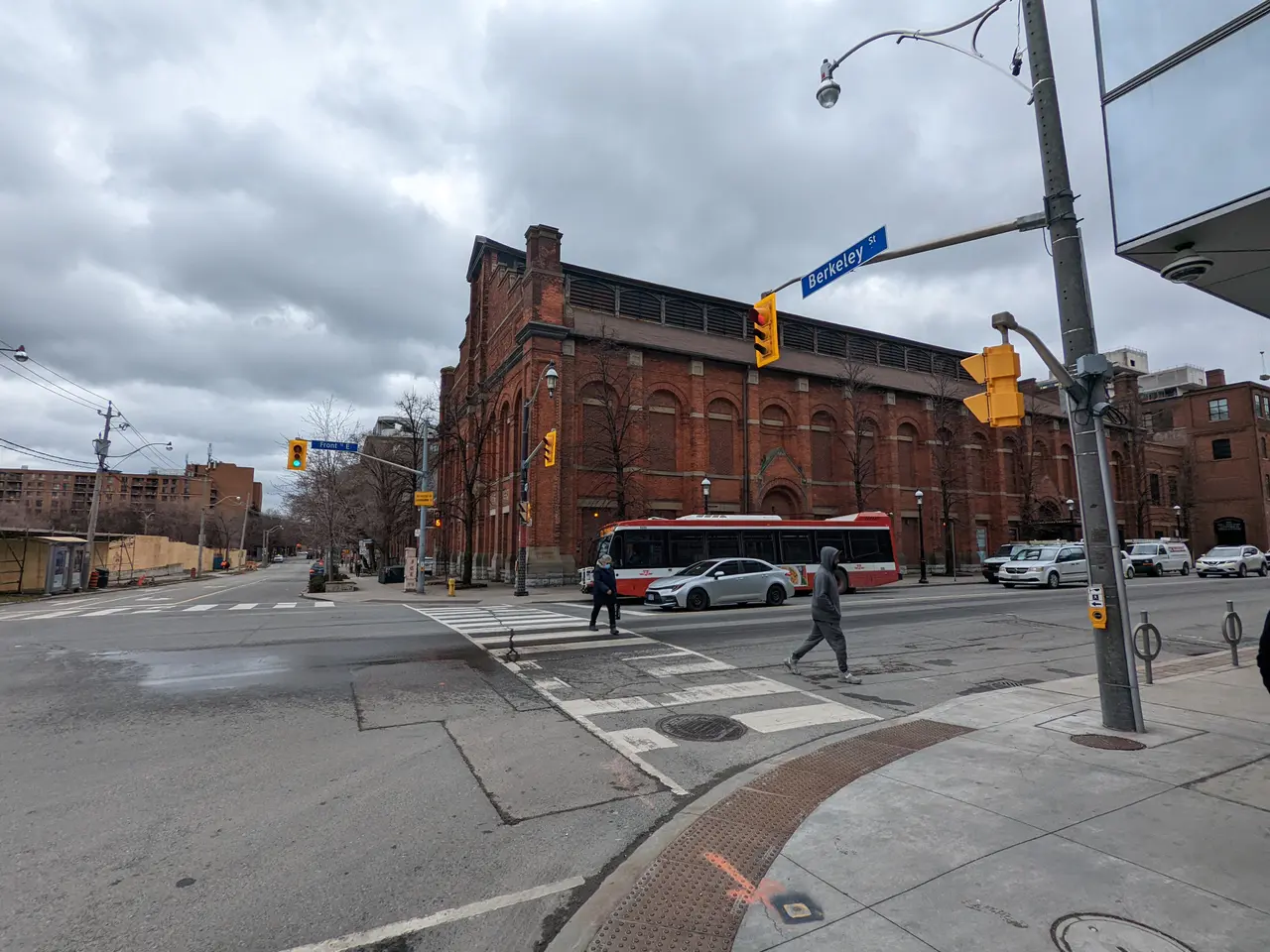 The image shows a city street with a bus stopped at a crosswalk. There are vehicles on the road,...