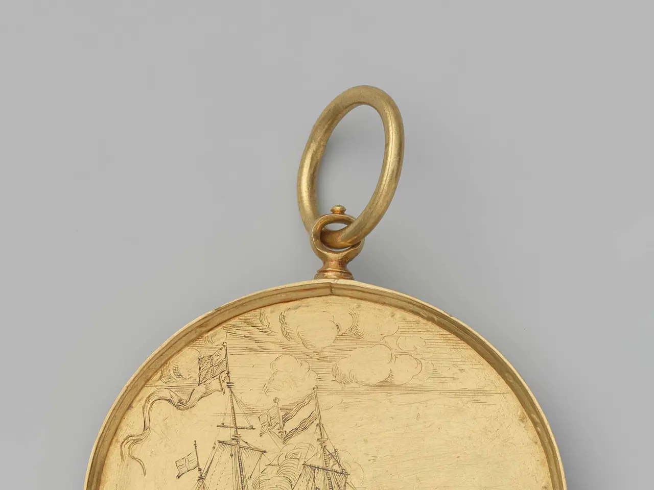 The image shows a gold pocket watch with a drawing of a ship on it against a white background.