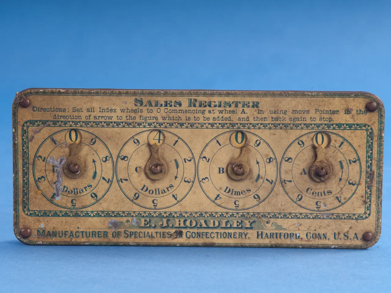 The image shows an old-fashioned sales register on a blue background. The board has text and...