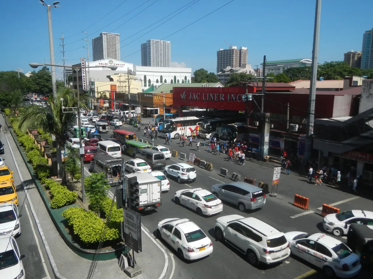 The image shows a bustling city street filled with lots of traffic, including cars, buses, and...
