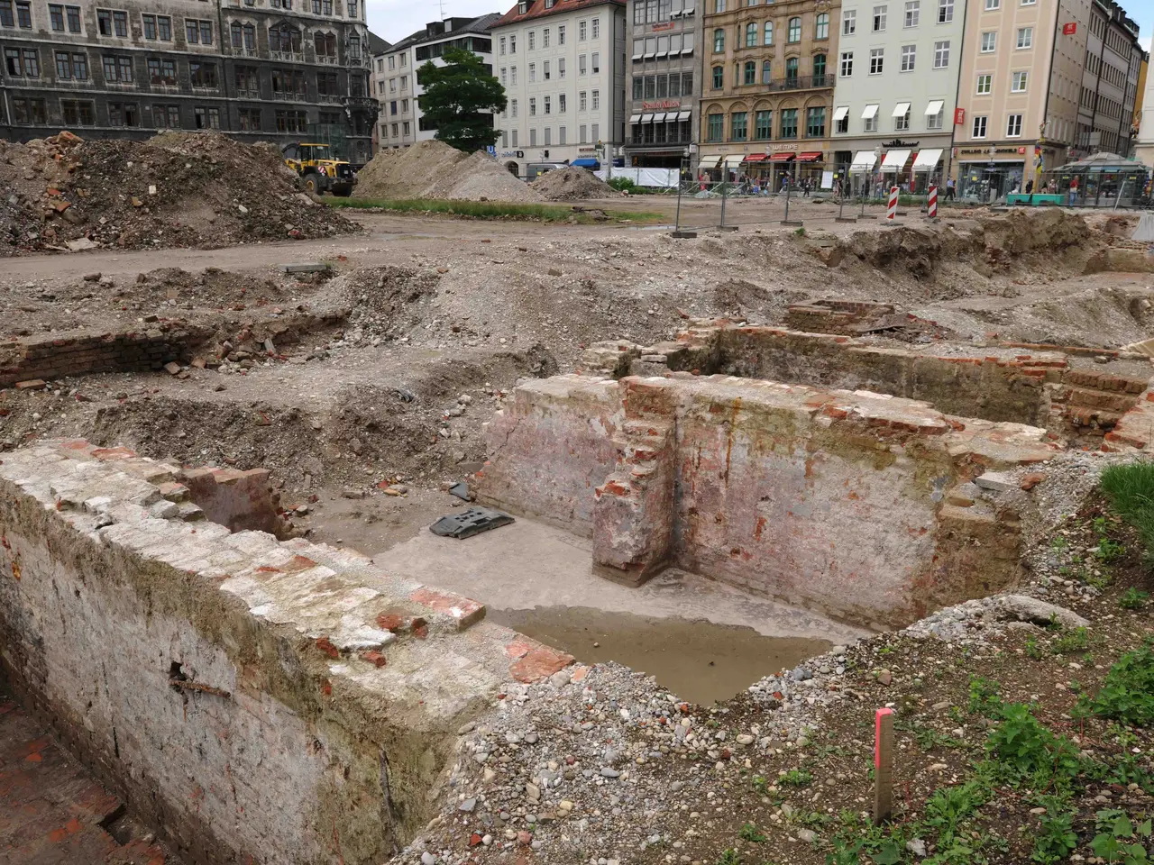 The image shows the ruins of an ancient Roman city in the middle of a city, surrounded by buildings...