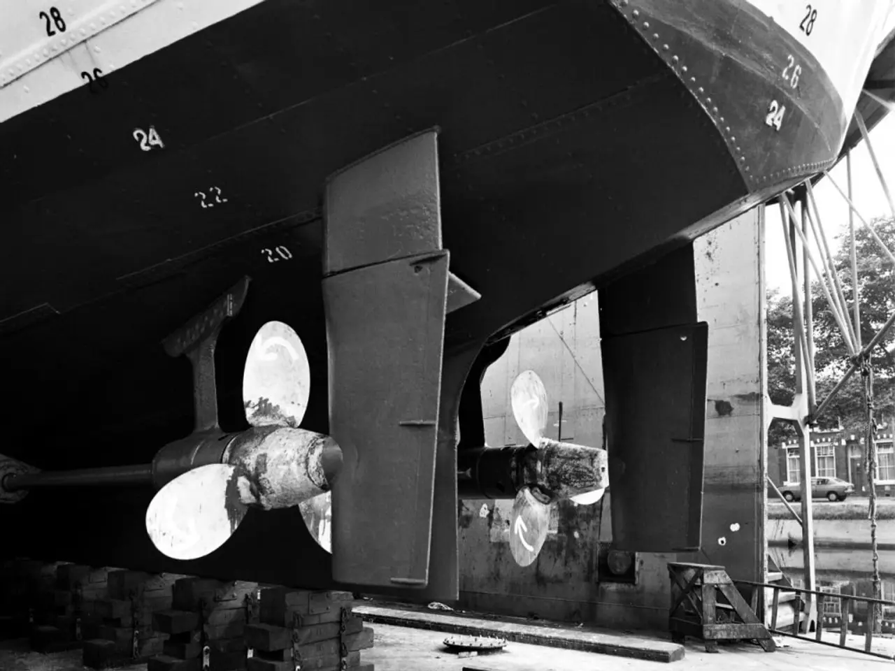 The image shows a black and white photo of a boat with a propeller on it, surrounded by a few...