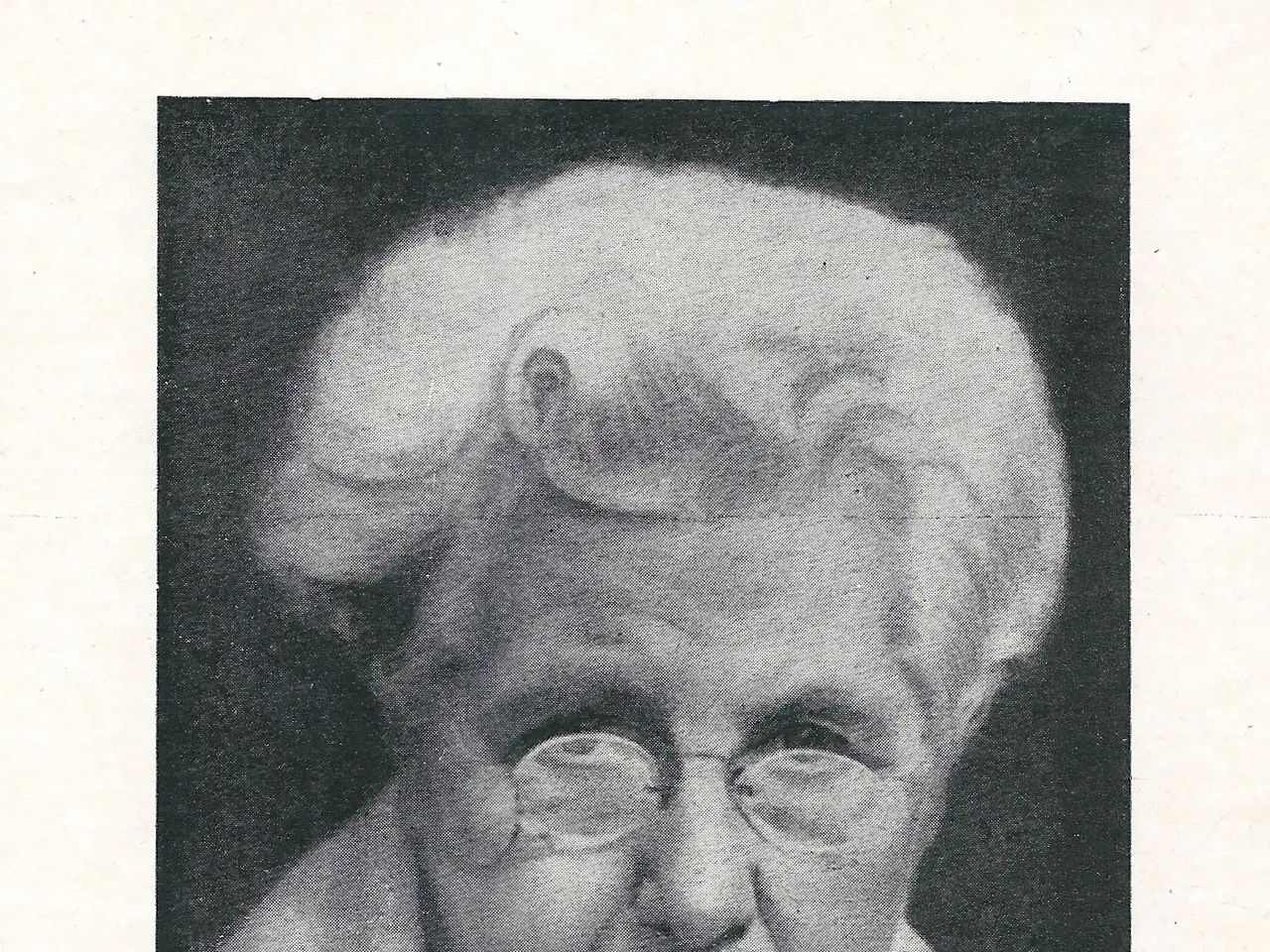 The image shows a black and white photo of an elderly woman wearing glasses. At the bottom of the...
