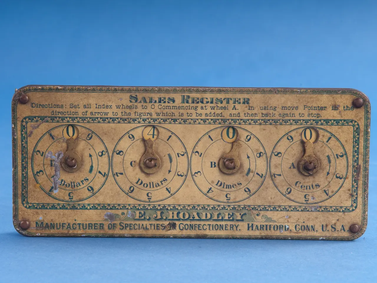 The image shows an old-fashioned sales register on a blue background. The board has text and...