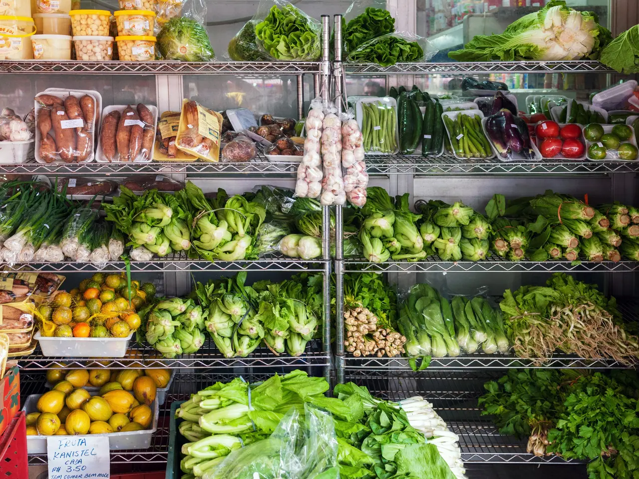 The image shows a grocery store filled with a variety of fresh produce, including vegetables,...