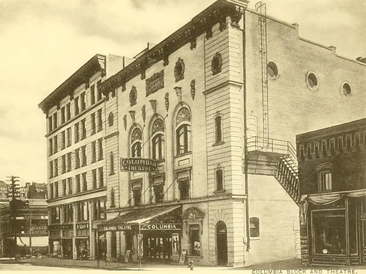 The image shows an old building on the corner of a street, with windows, name boards, electric...