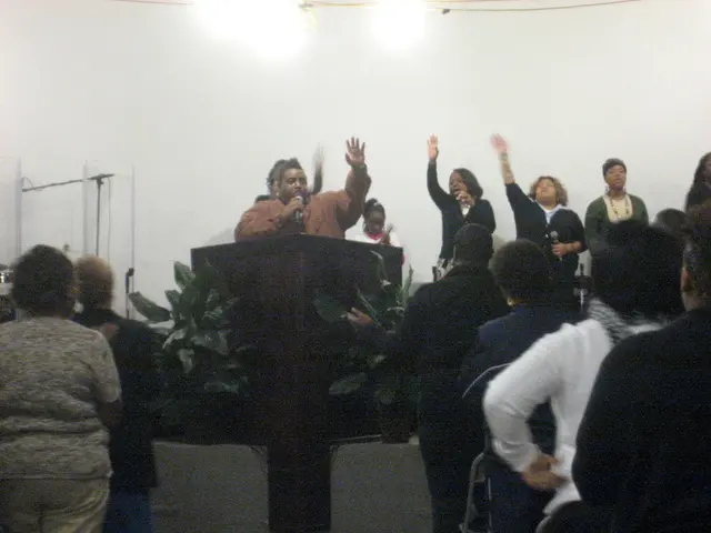 In the image we can see there is a man standing near the podium on the stage and he is holding a...