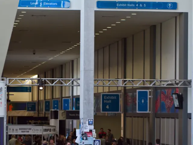 In the picture we can see an airport waiting hall with some people sitting on the chairs, and some...