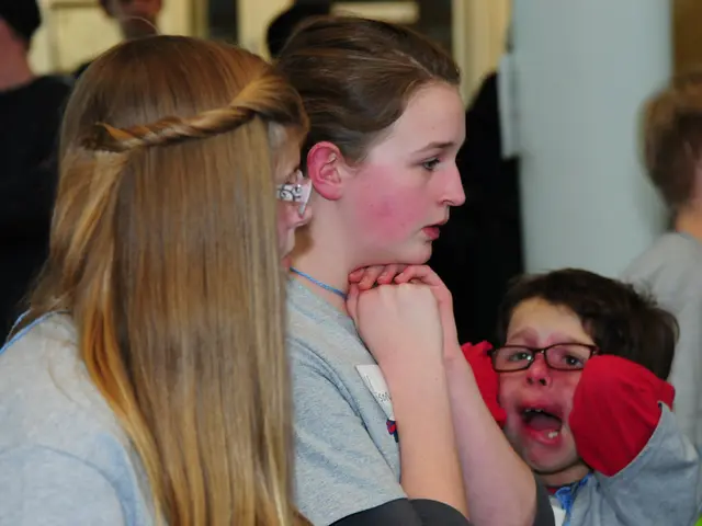 In front of the picture, we see two girls. Beside them, we see a boy who is wearing the spectacles...