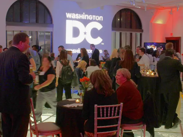 This image is clicked in a restaurant. To the left, there is a man standing and wearing black suit....