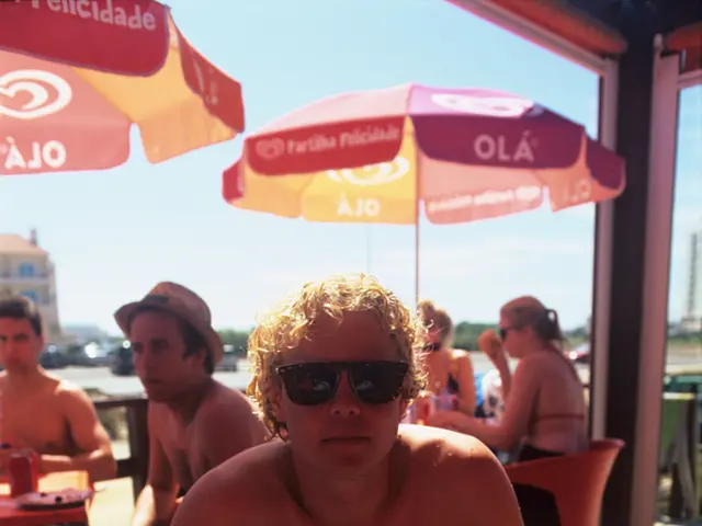 In this image there are three men sitting on the chair, there are two women sitting on the chair,...