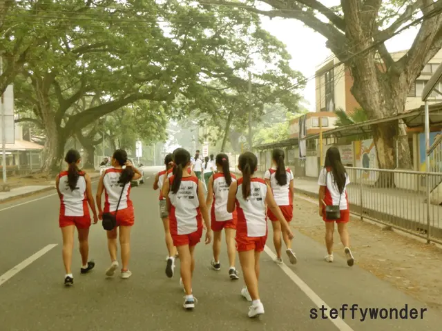 In this image I see number of people and I see that these women are same dress and I see that this...