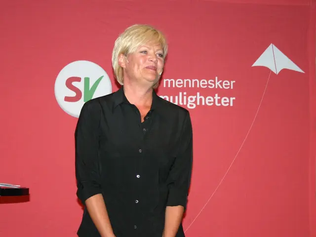 In this picture there is a woman who is wearing shirt and mic. Behind her I can see the banner. On...