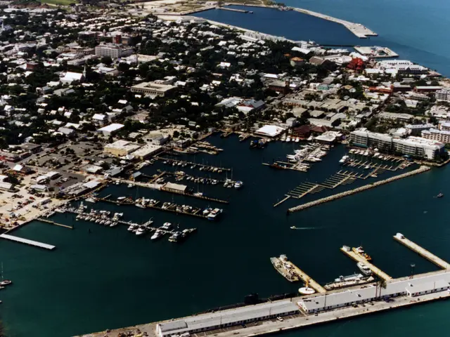 In this picture there is a top view of the city full with many buildings and seawater. In the front...
