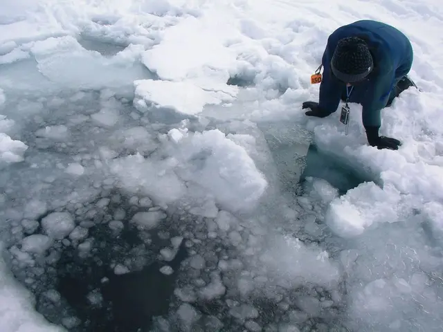 In this image there is ice in the middle. On the right side there is a person who is kneeling down...