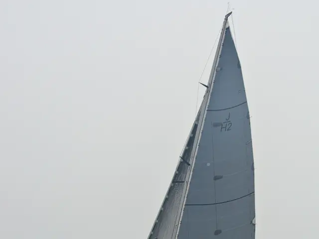 In this image we can see ship with persons on the water and sky in the background.