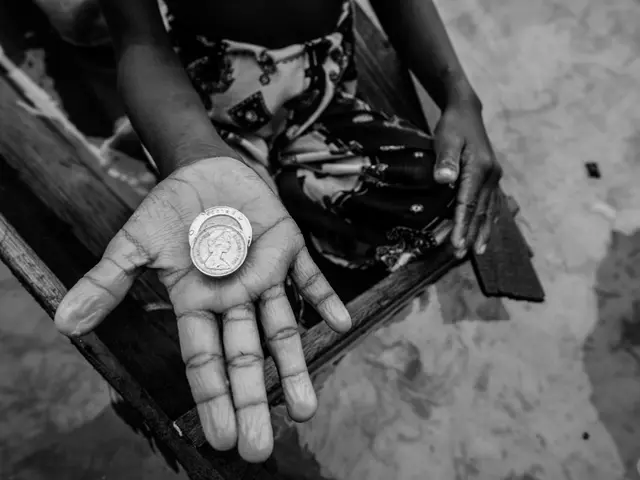 I see this is a black and white image and I see 2 coins on the hand of a person.
