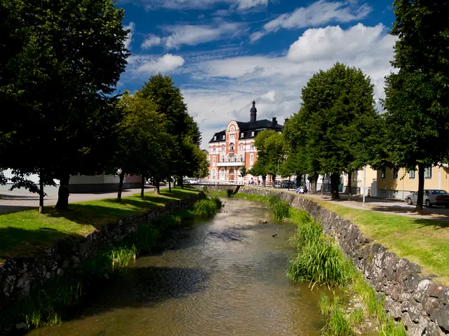 In this image there is a canal on either side of the canal there are trees and roads, on that road...