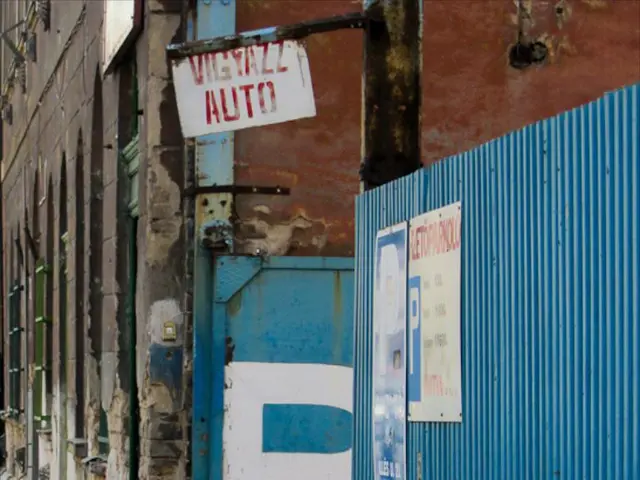 In this picture we can see a building,, on the right side we can see a blue color sheet and three...