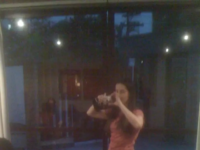 This is the woman standing and holding a camera. On the left side of the image, I can see a person...