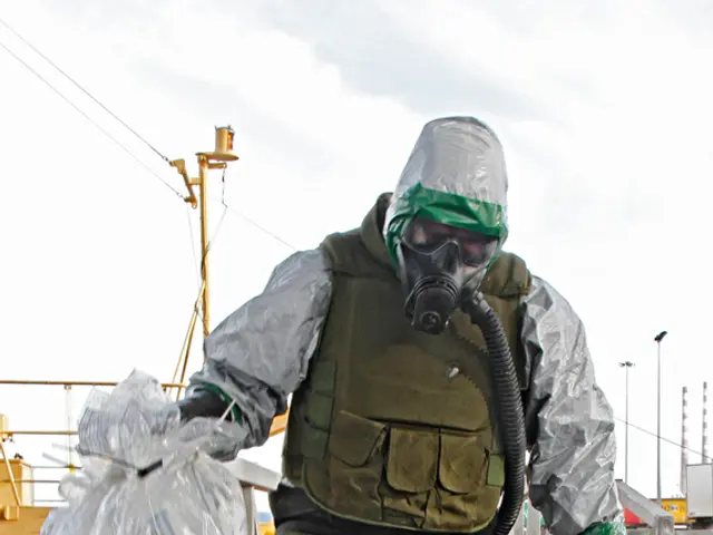 In the middle of this image, there is a person in a uniform, having a mask, glove and placing a leg...