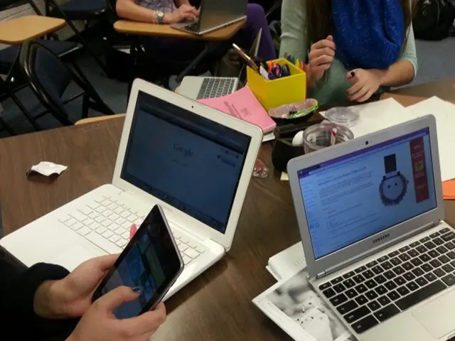 Here a person is sitting on the chair and holding an electronic gadget.