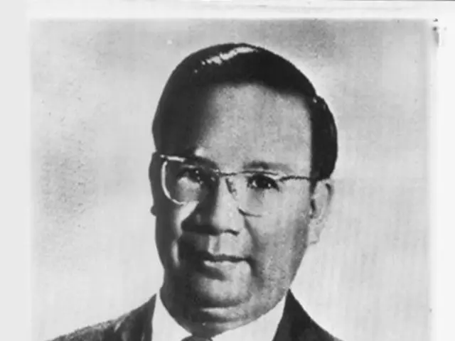 This is a picture of a man wearing suit, there is text below. This is a black and white picture.