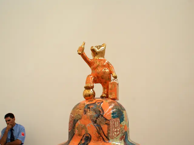 In this picture we can see statue. On the bottom left corner there is a security person who is...