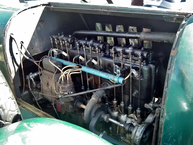 In the middle of this image, there is an engine of a vehicle. On the left side, there is a wheel of...