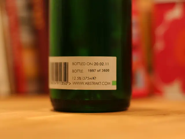In this image we can see there is a label with some text on the bottle which is on the table.