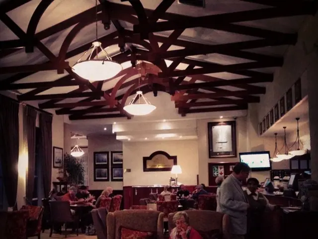 There are few people sitting on the chairs and few people standing. I can find empty chairs. This...