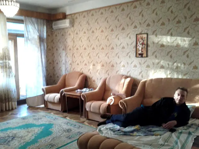 in this image this is a picture of a living room where we have a chandelier, curtain , door, air...