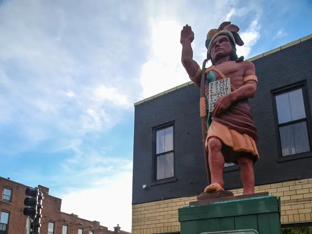 As we can see in the image there is a statue, buildings, traffic signal, cars, bicycles, few people...